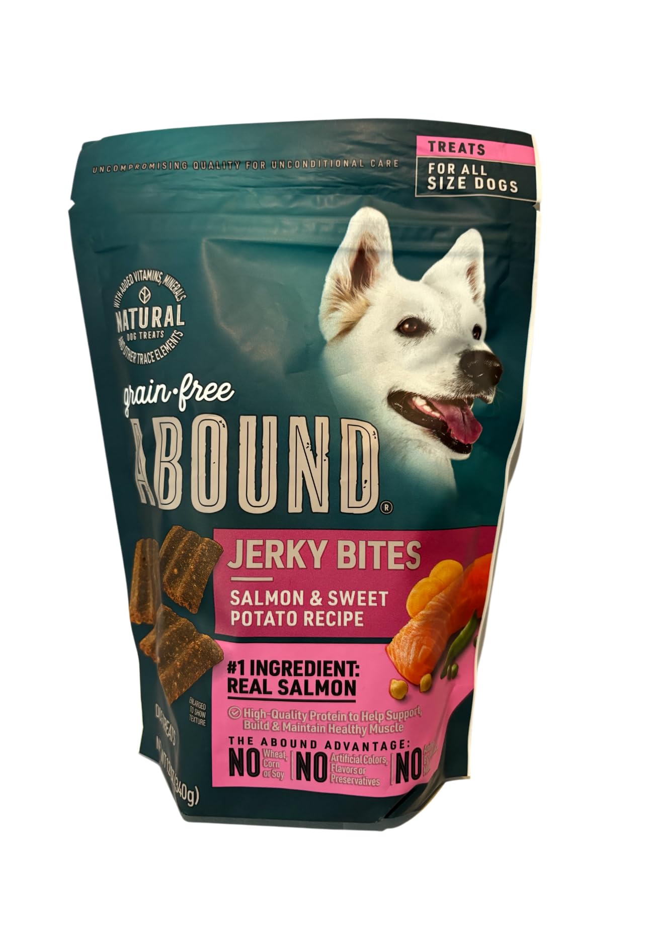 Abound salmon and sweet potato dog treat shown with a dog enjoying a bite.