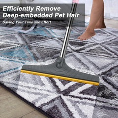 B-Land carpet rake shown with its adjustable long handle extended.