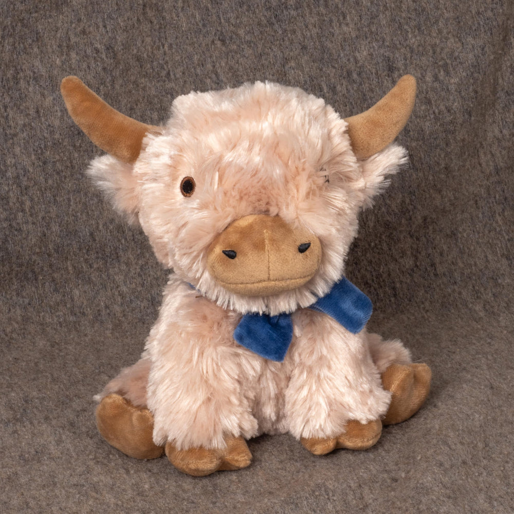 Fuzzl Highland Cow plush dog toy shown as a cuddly companion.