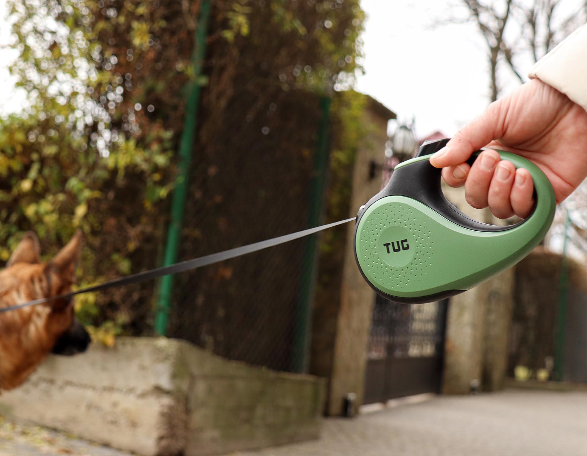TUG retractable dog leash thumb lock and unlock control shown close up.